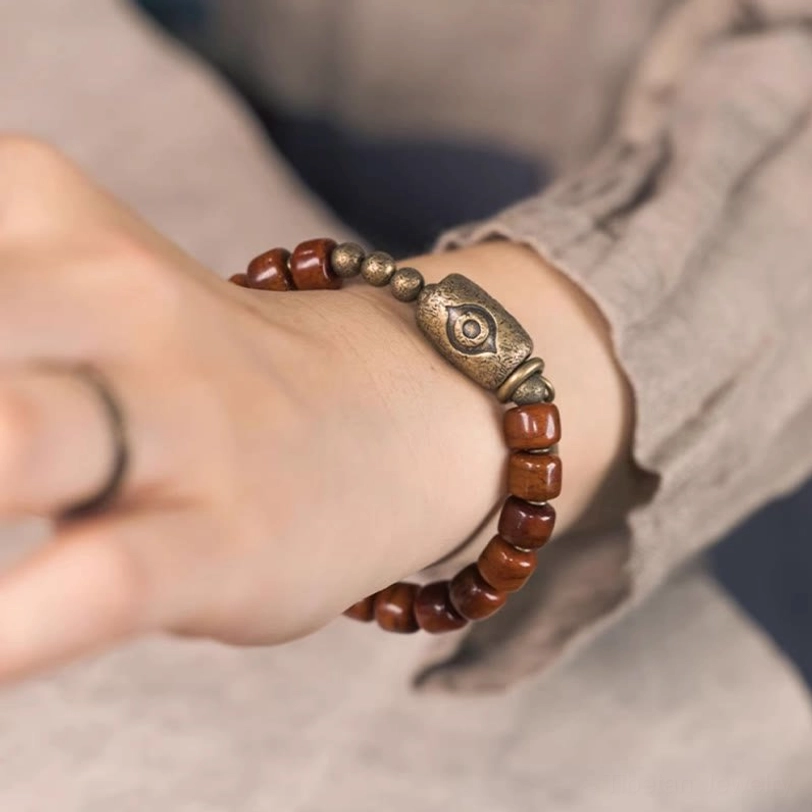Tibetan bone Dzi bracelet worn on left wrist against natural linen clothing, authentic lifestyle wear demonstration
