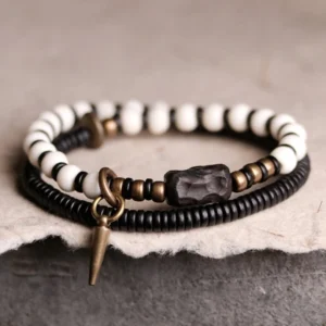 Tibetan bone ebony wood copper couple bracelet pair overhead view showing beaded design and bronze hardware on dark mat
