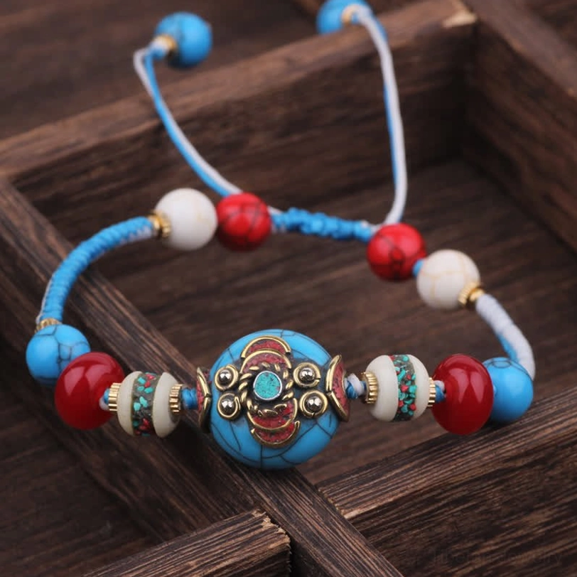 Blue braided rope Tibetan healing bracelet with turquoise red and white beads ornate enamel center