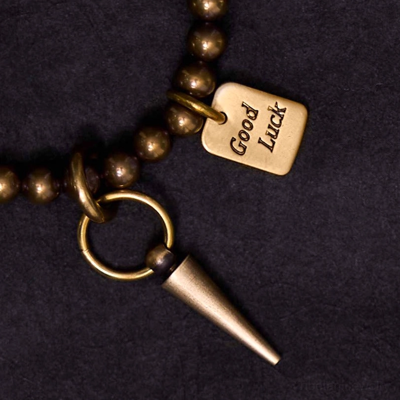 Close-up detail shot of tibetan bracelet charms including square good luck tag and spike pendant