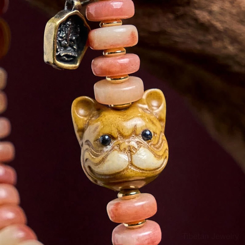 Detailed flat lay of Tibetan bracelet components showing individual camel bone beads, green jade stone, carved metal pendant, and pug ornament