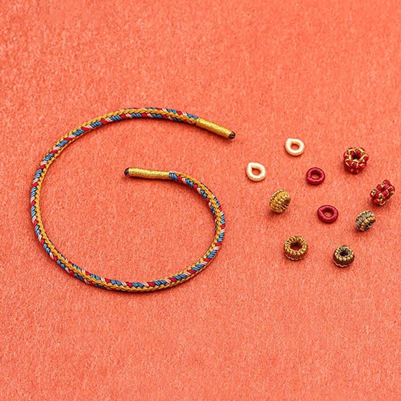 Artisan Dunhuang bracelet components showing braided rope with decorative beads and knots