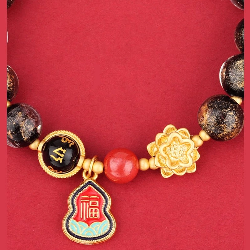 Close-up detail of Tibetan Om Mani Padme Hum bracelet showing spotted Liuli glass beads, gold lotus decoration, and pendant charm