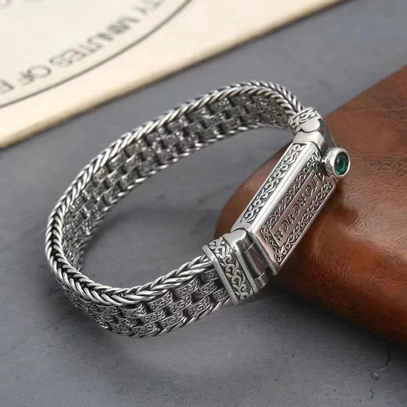 High angle view of the Tibetan copper bracelet displaying the braided chain design, Tang Dynasty floral engravings, and secure buckle clasp mechanism