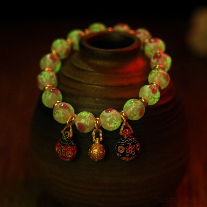 Tibetan protection bracelet with glow-in-the-dark fluorescent green glass beads and enamel charms