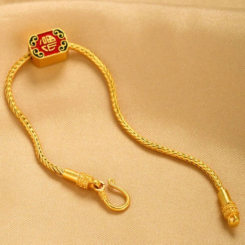 Close-up detail of gold braided chain link and spring clasp mechanism for Tibetan bracelet