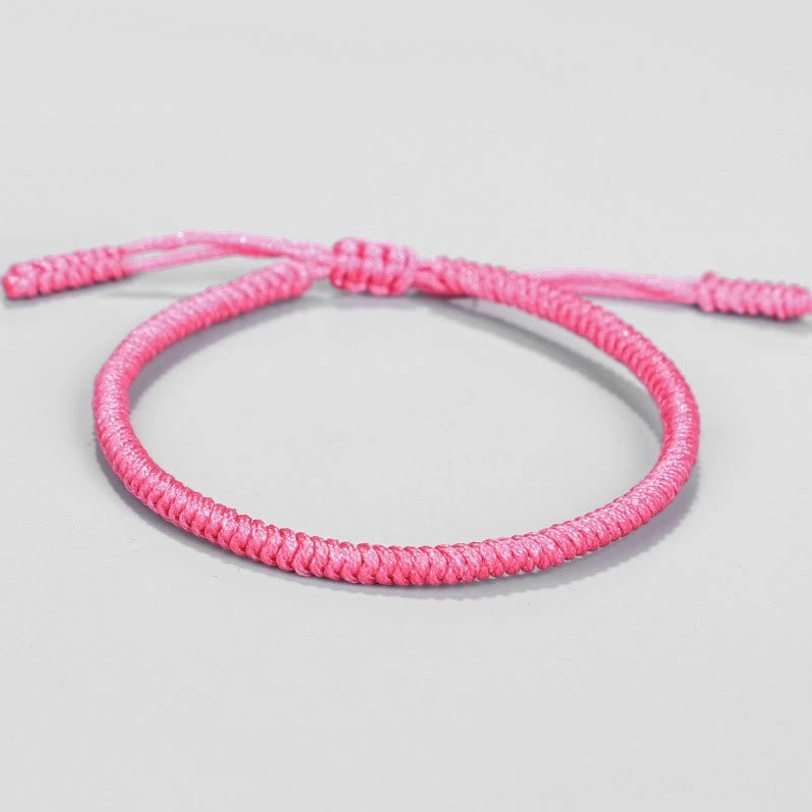 Top-down view of Tibetan King Kong knot braided bracelet showing ombre pink color and knot fastener closure