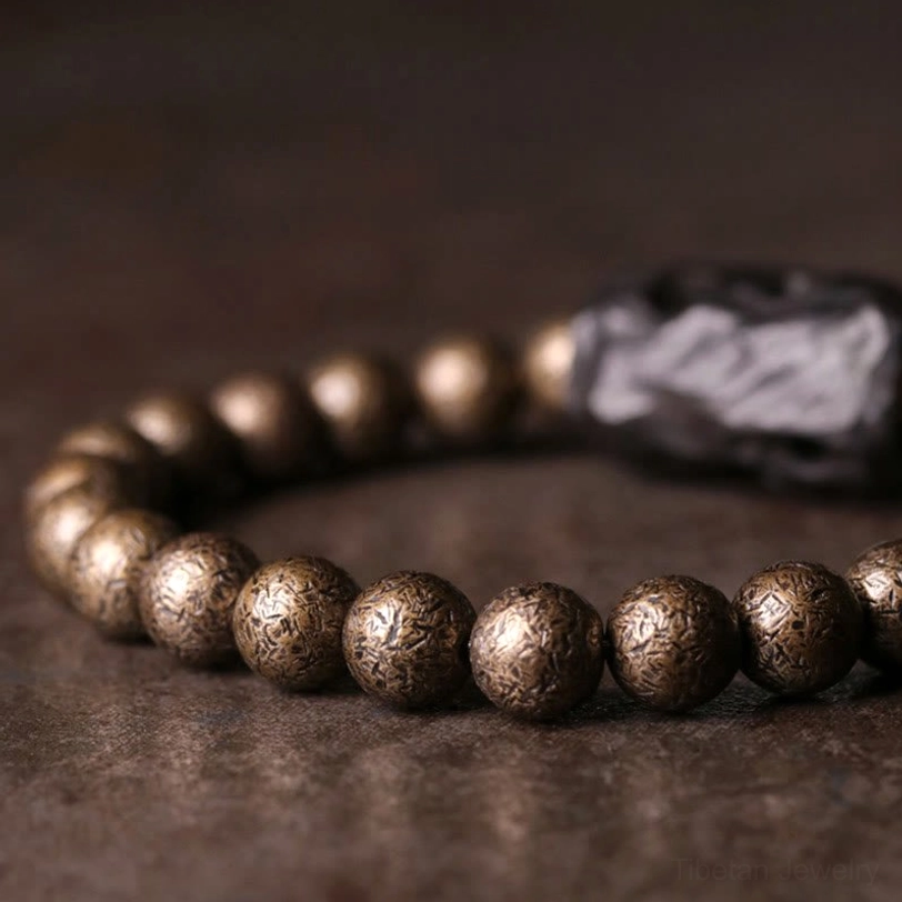 Tibetan balance bracelet side angle showing textured copper beads and dark wood center accent
