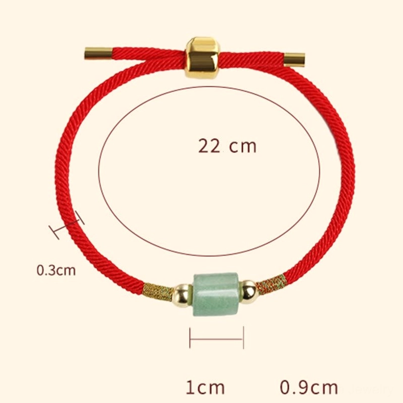 Sized Tibetan woven bracelet display showing red braided rope, green gem bead, gold hardware with measurement labels on white background