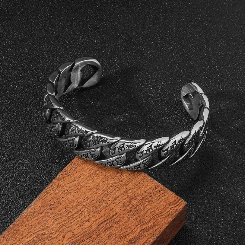 Vintage twisted titanium steel mantra bracelet in dark silver tone, overhead angle view with textured surface