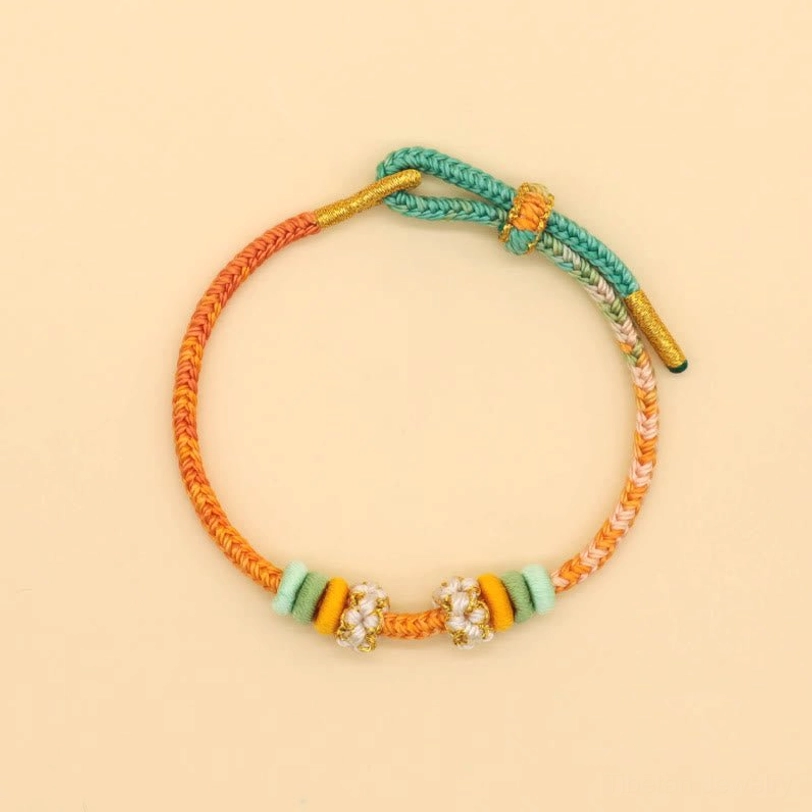 Warm tone handmade braided peace knot bracelet in orange-red and teal with floral bead decorations