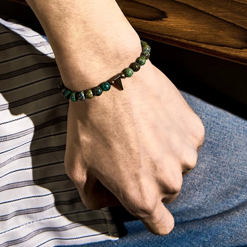 Woman wearing turquoise copper balance bracelet on wrist - casual denim styling