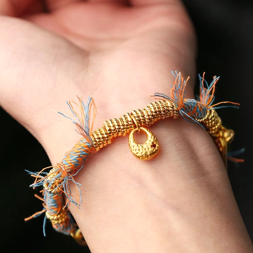 Tibetan lucky bracelet worn on human wrist showing real-life fit and multicolor braided rope design with gold charm pendant