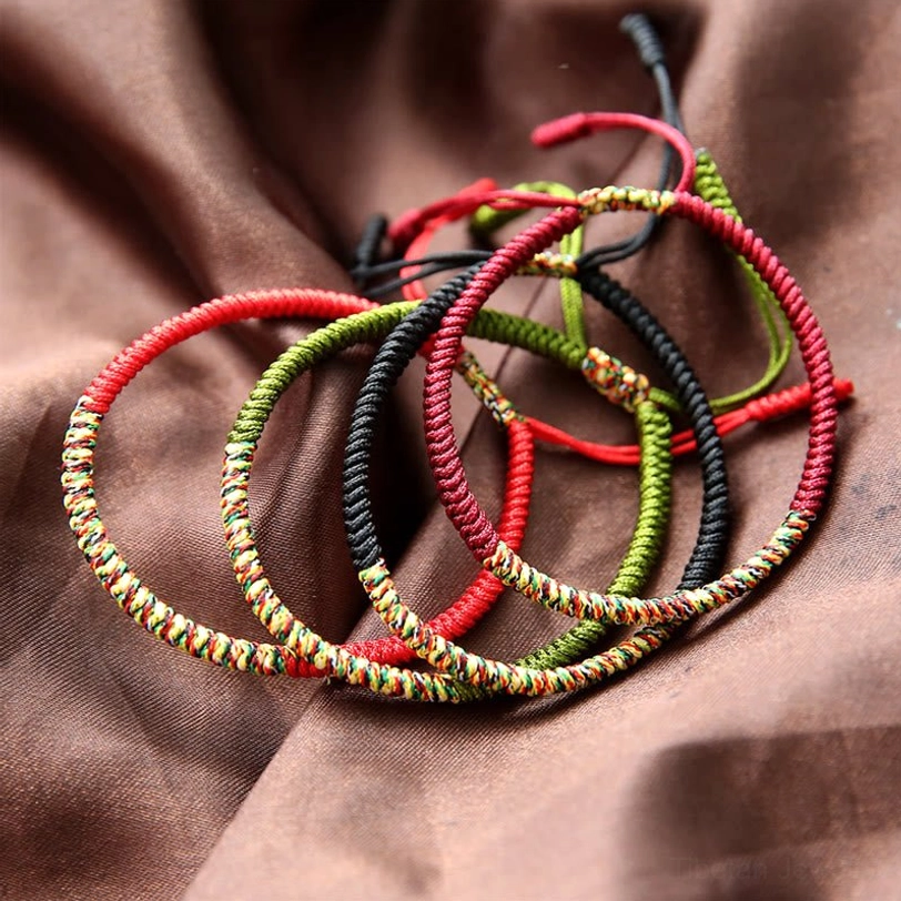 Stacked Tibetan multicolor braided bracelets showing various King Kong knot patterns and color combinations, close-up flat lay