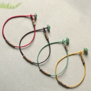 Set of four multicolor Tibetan braided bracelets in green, red, yellow and brown with green aventurine pendants
