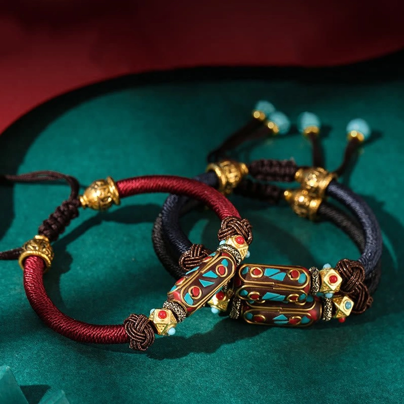 Two Tibetan prayer braided bracelets side by side showing wine red and black rope color options with vintage enamel decorative beads