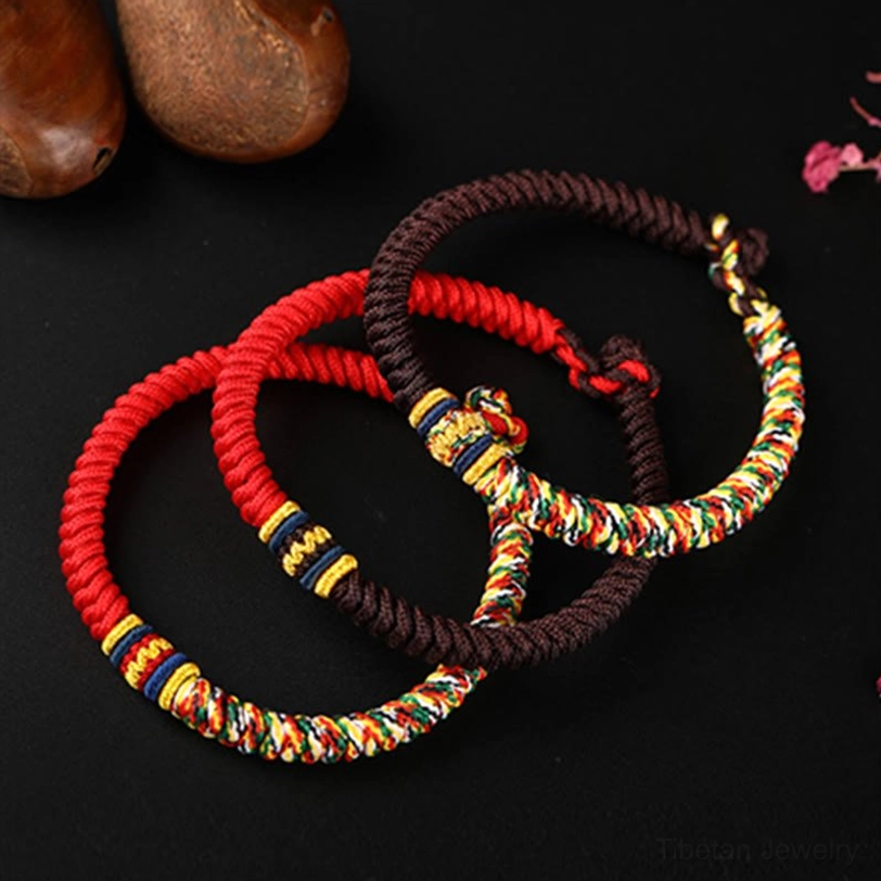 Multiple Tibetan King Kong Knot bracelets in red brown and multicolored styles flat lay comparison