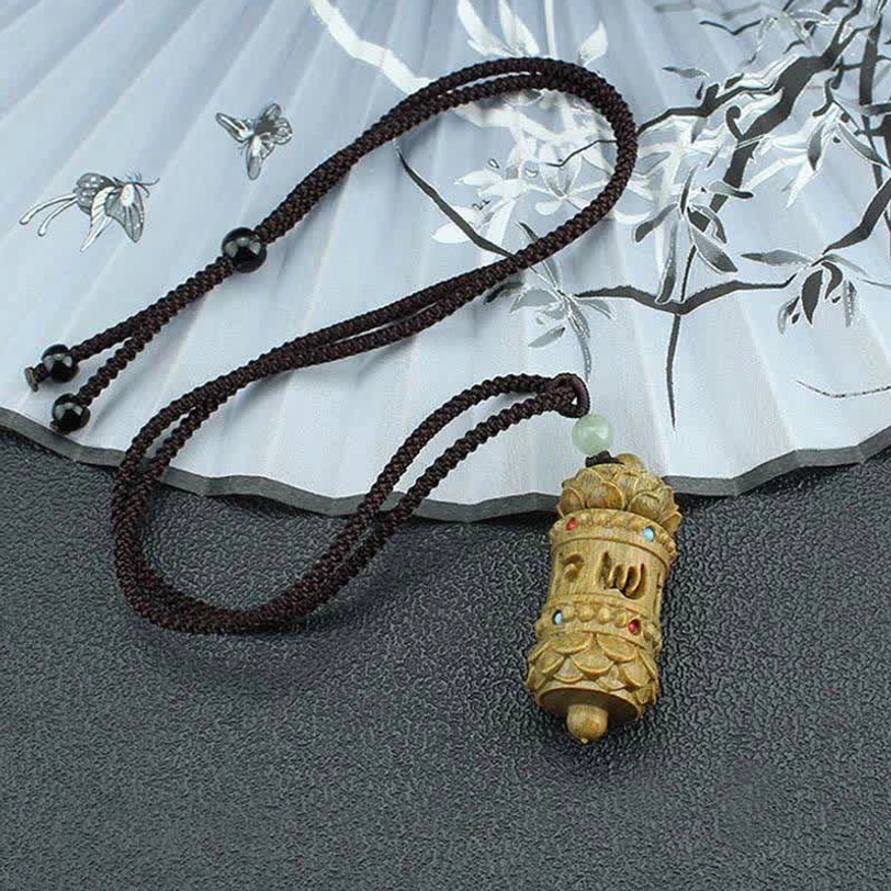 Black braided cord Tibetan necklace with wooden pendant and adjustable beads, flat lay against traditional ink painting backdrop