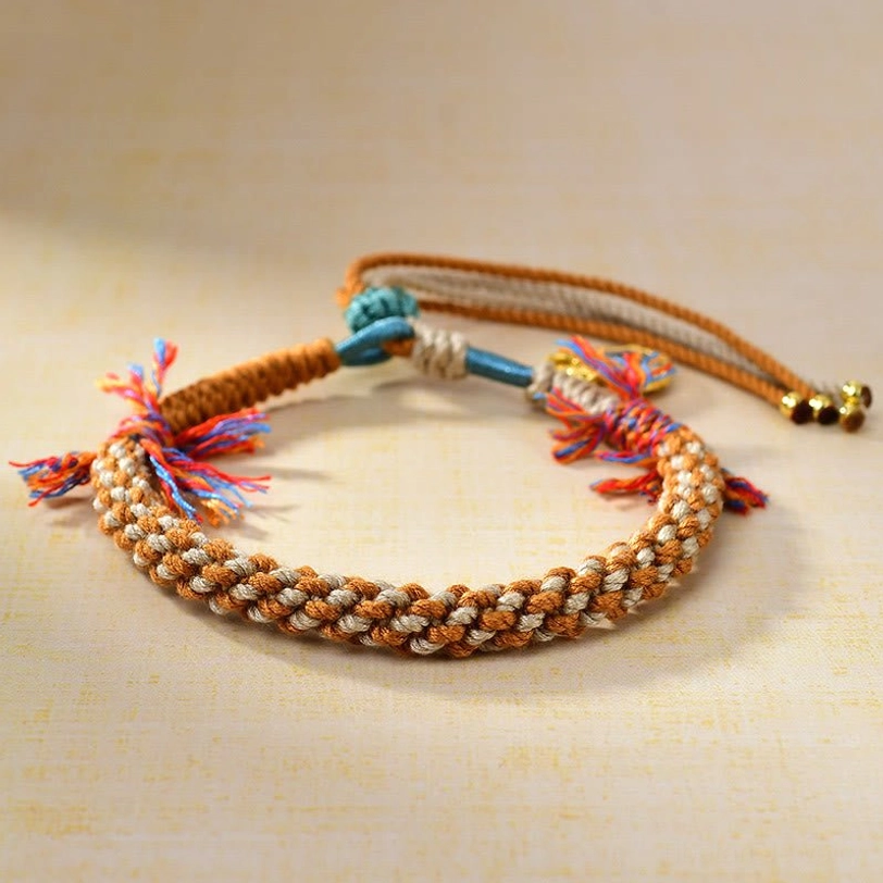 Handmade Tibetan braided wealth bracelet with multicolor rope, adjustable knot closure, and decorative tassels - overhead view