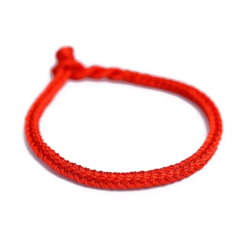 Bright red tibetan eight-thread peace knot blessing bracelet front flat lay showing neat woven cord texture