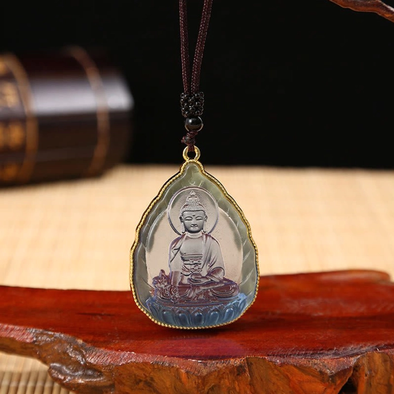 Blue-purple translucent Tibetan Buddha crystal pendant with seated Buddha engraving, gold rim, and beaded necklace