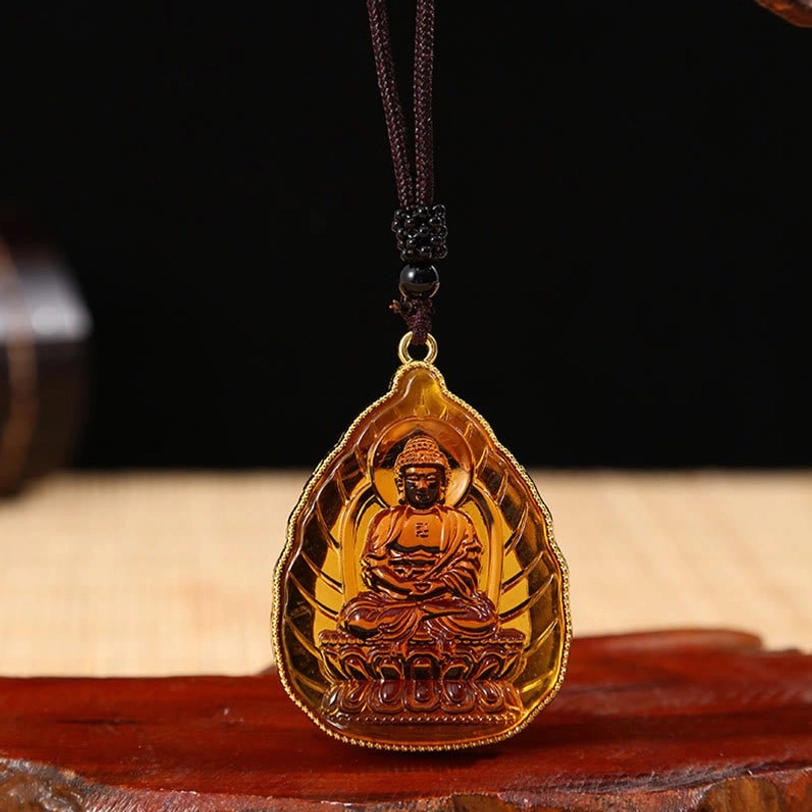 Brown translucent Tibetan Buddha crystal pendant with seated Buddha engraving and gold edge on black beaded cord