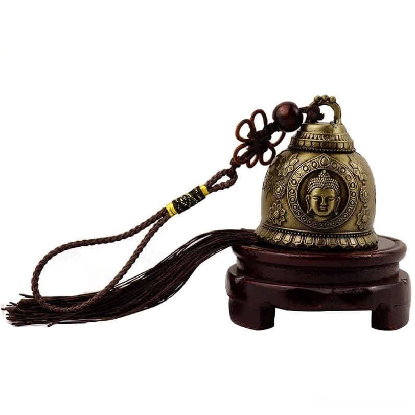 Buddha embossed wind chime bell with bronze metal texture displayed on wooden stand, spiritual decoration