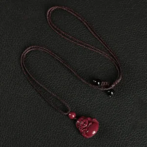 Tibetan cinnabar Buddha pendant necklace in deep red with woven brown rope and decorative beads