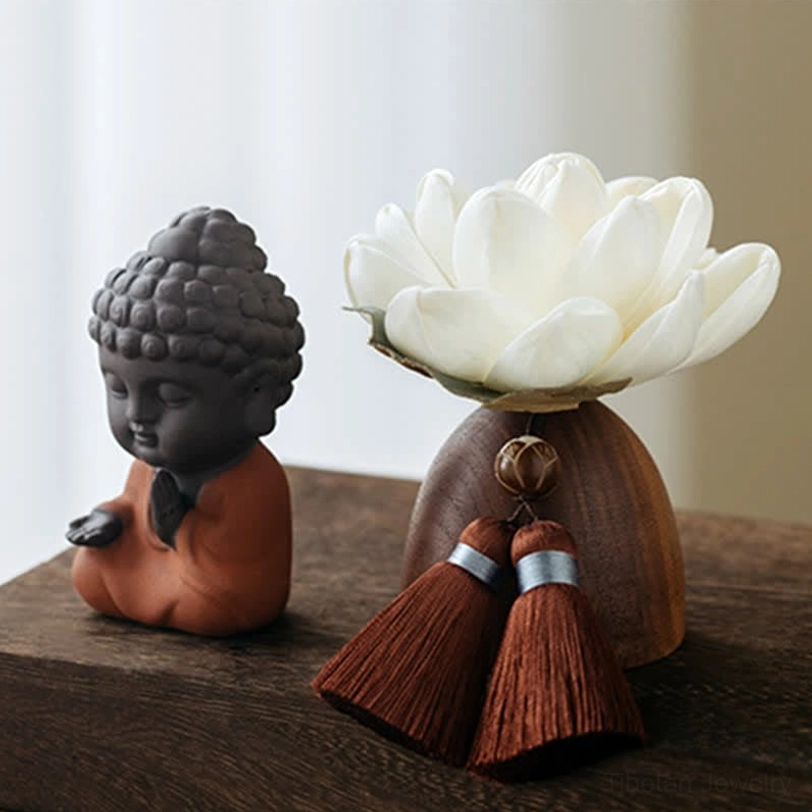 Serene Buddha meditation decoration with white lotus flower and reddish-brown tassels on wooden base, side profile view