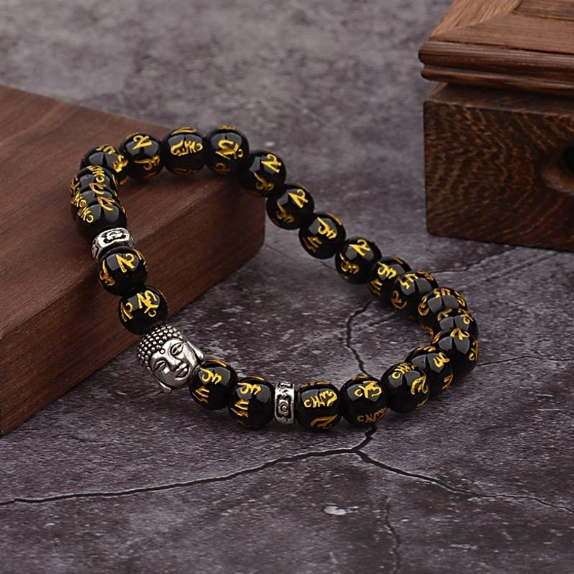 Angled lifestyle shot of authentic Tibetan Om Mani Padme Hum beaded bracelet with silver charm and gold mantra engravings