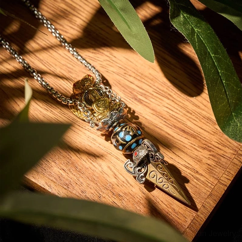 Complete Tibetan Om Mani Padme Hum Vajra pendant necklace with metal chain, overhead angle showing full design with engraved spike and two-tone finish