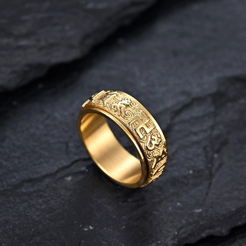 Om Mani Padme Hum gold titanium spinner ring with engraved scroll patterns and rotatable band for meditation