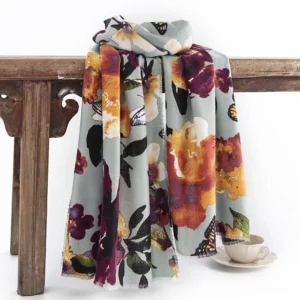 Tibetan butterfly floral shawl in dusty blue hanging on vintage wooden furniture display