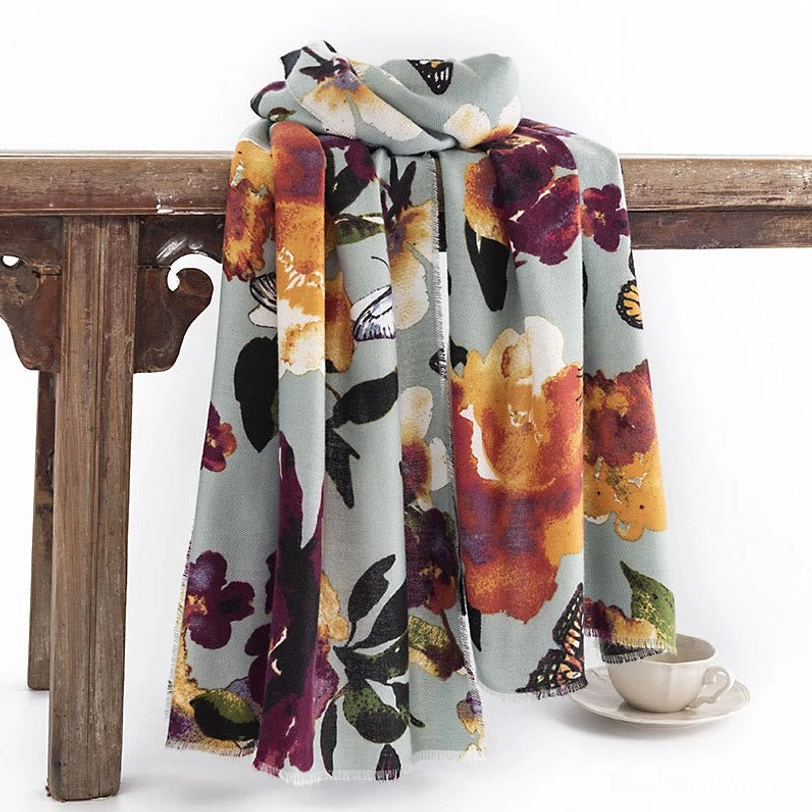 Tibetan butterfly floral shawl in dusty blue hanging on vintage wooden furniture display