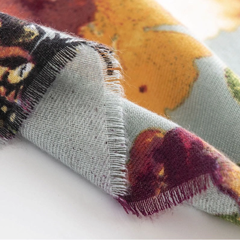 Tibetan butterfly scarf hem close-up showing raw frayed edge and warm-toned floral pattern