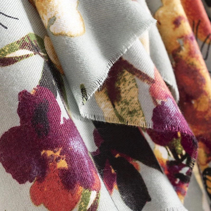 Angled macro view of Tibetan butterfly scarf print on dusty blue base fabric