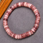Tibetan camel bone beaded bracelet with gradient rose-pink disc beads on premium elastic string, overhead view on natural fabric