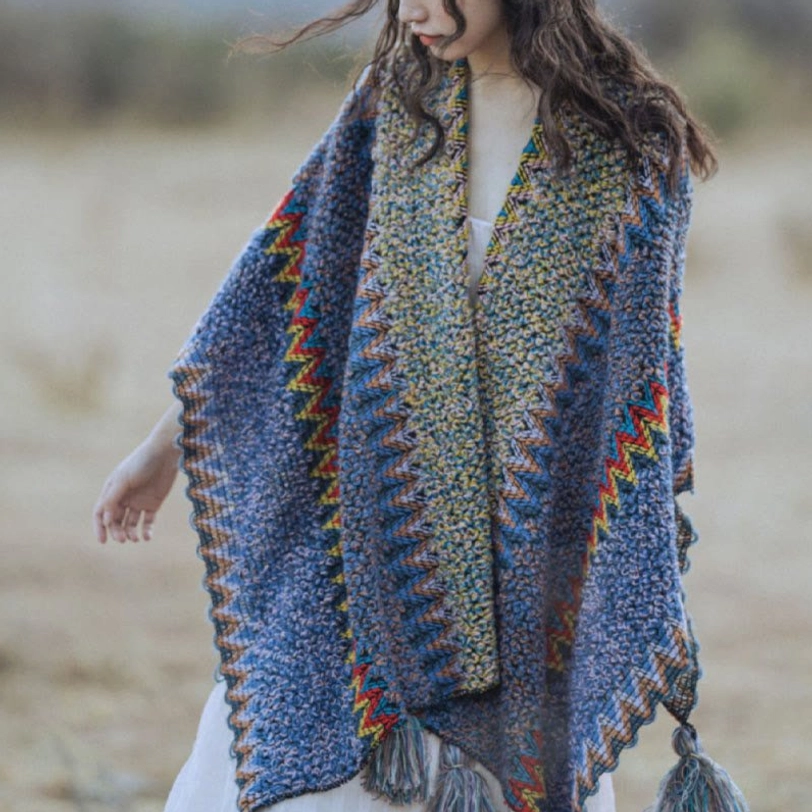 Low front view of open-front Tibetan knitted cape with contrast color border, tassel accents and thick warm knit