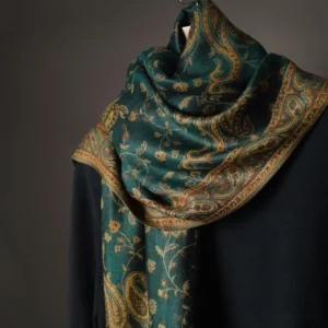 Close-up detail of soft woven tibetan paisley fabric showing teal base with intricate gold-brown floral motifs
