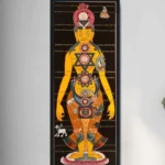 Tibetan chakra thangka painting hung on minimalist gray wall, showing golden patterns and Tibetan script with black frame, chakra meditation artwork