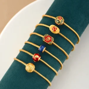 Collection of Tibetan Buddhist charm bracelets featuring Fu character, Koi fish, and lucky symbols in gold