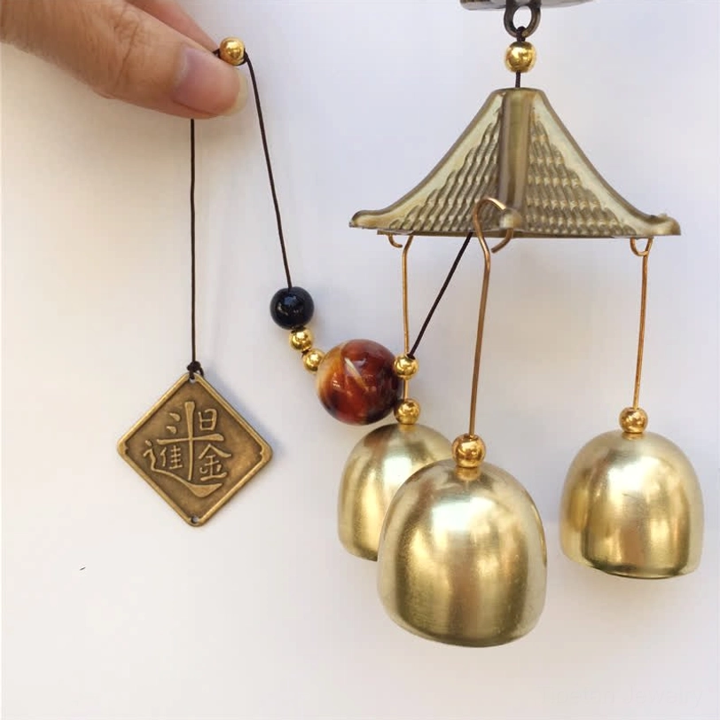 Handmade Lucky Cat Wind Chime held in hand showing beaded cord brass bells engraved pendant details