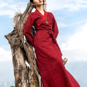 Tibetan wrap maxi dress with auspicious cloud pattern in burgundy, full-length outdoor model shot showing cross V-neck and waist tie detail
