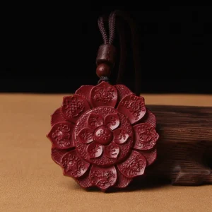 Tibetan cinnabar lotus blessing pendant necklace with Om Mani Padme Hum carving, front view on brown table with waxed cord and wooden beads