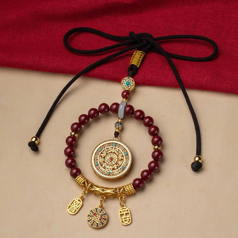 Tibetan peace blessing car hanging decoration displayed on red fabric with knotted adjustable black cord and complete pendant set