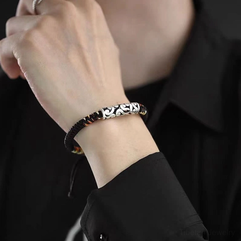 Tibetan auspicious cloud luck bracelet worn on adult wrist showing comfortable fit with black and colorful braided cord