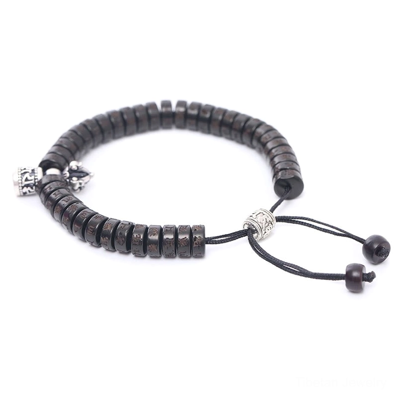 Tibetan prayer bracelet side angle showing natural coconut shell beads, silver alloy decorations, and black drawstring with bead stoppers