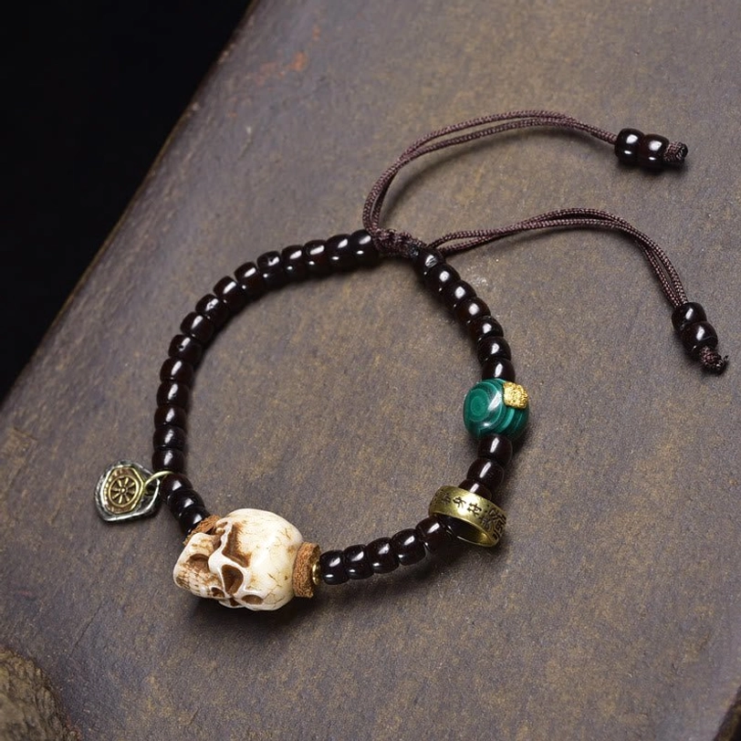 Black glass bead skull bracelet with green accent stone and bone skull pendant