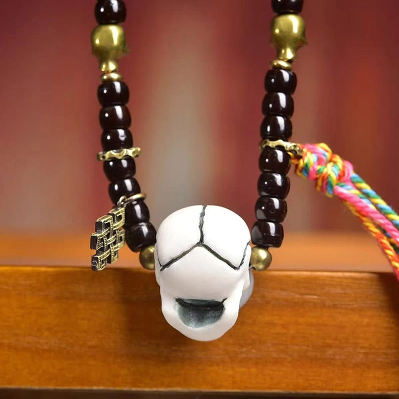 Tibetan coconut shell prayer bead bracelet with bone beads and colorful woven tassel close-up
