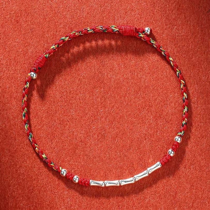 Colorful Tibetan handmade braided protection bracelet with multicolor red threads and silver metal beads, overhead view